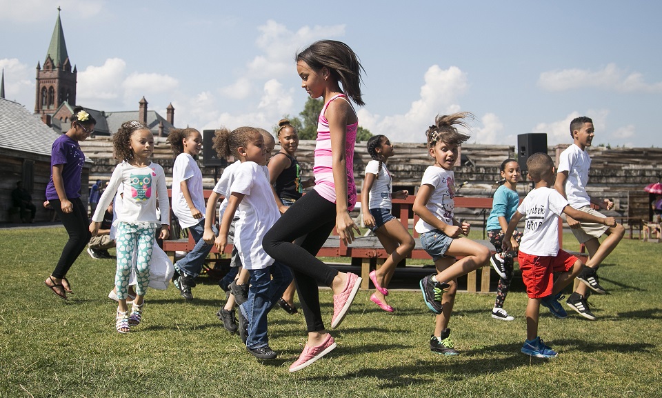 A group of kids dancing on the grounds of a historic fort