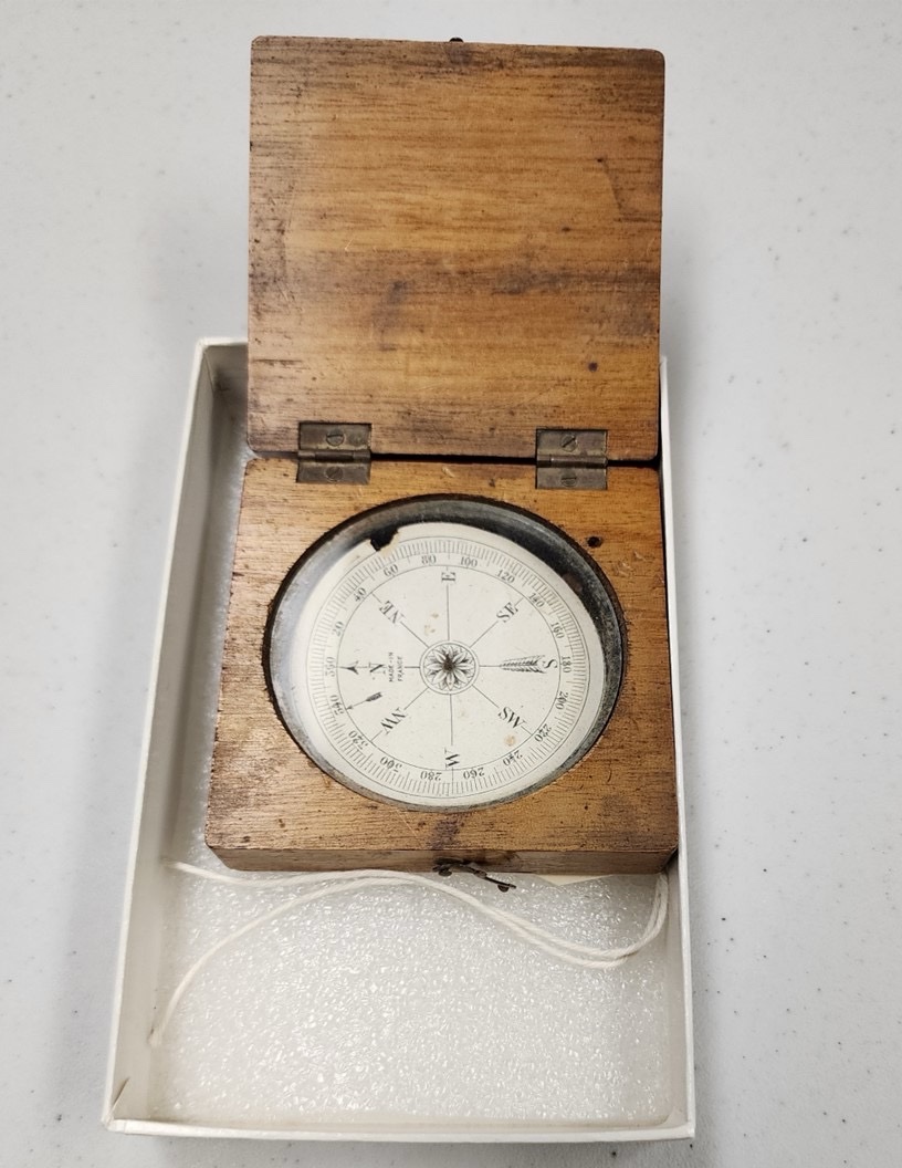 A wooden compass open and revealing its navigational element