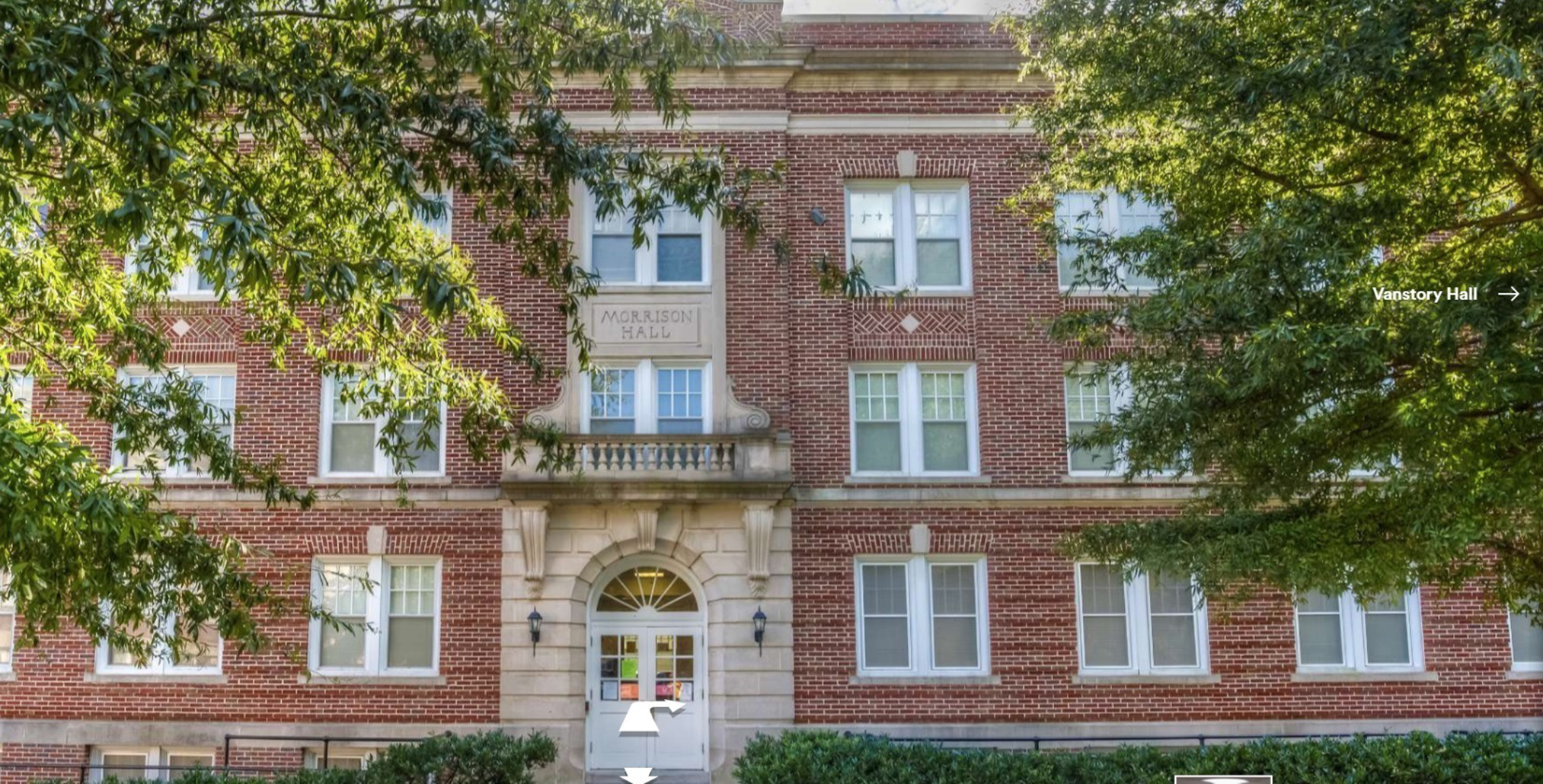 A large 3-story red brick building with a sign above the door saying "Morrison Hall" on a sunny day, two large trees on either side of the building.