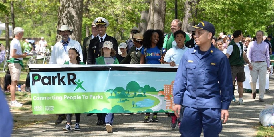People holding a Park Rx Day banner in a parade