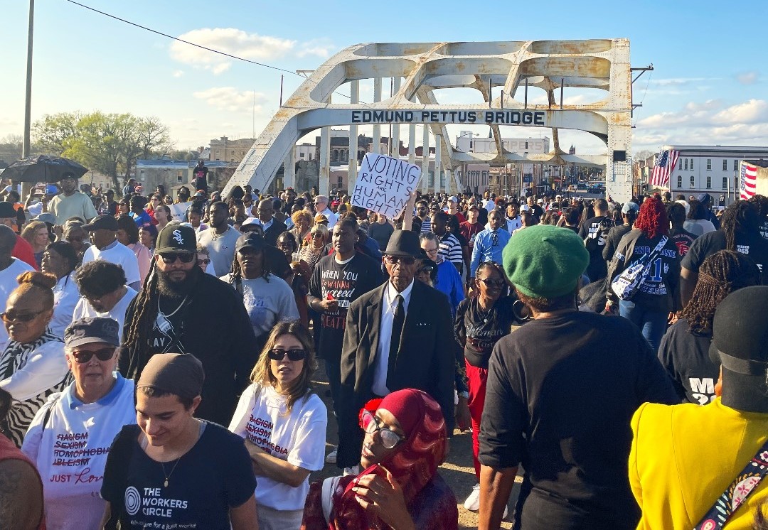 Pettus Bridge A large gathering of people walk across the Pettus Bridge.