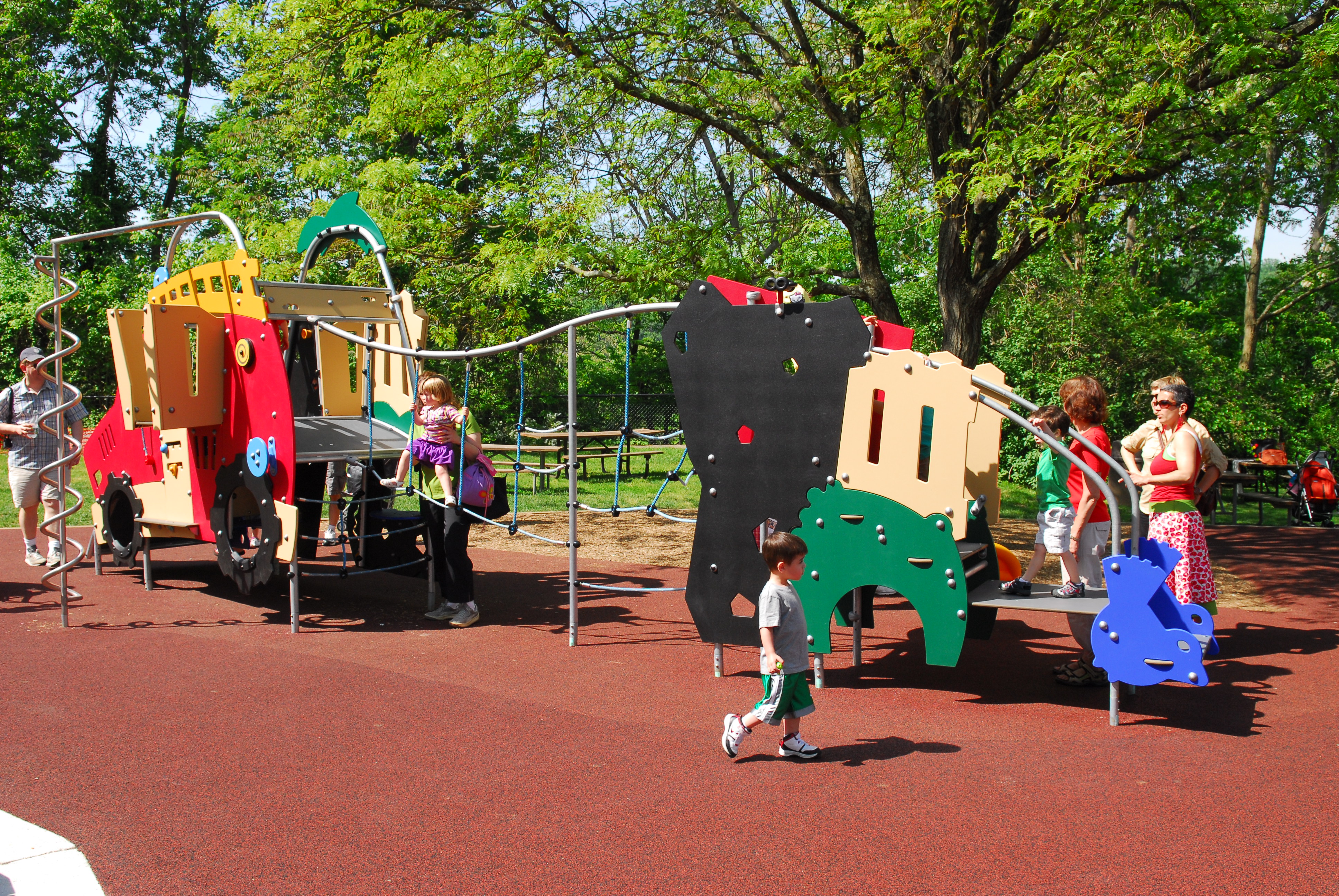 A playground structure at Glen Echo Park with several children playing on it.
