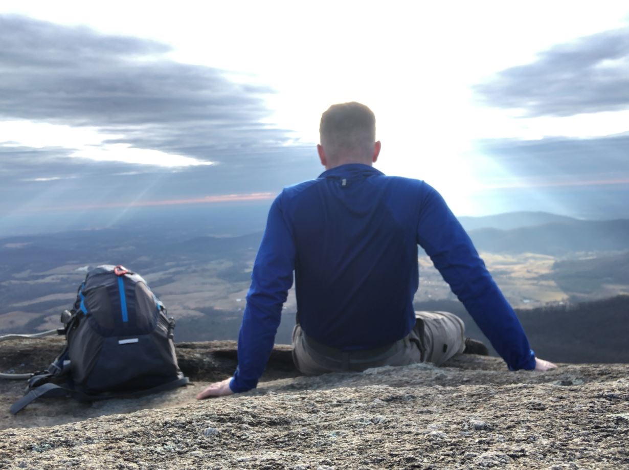 Man sitting on a rock ledge