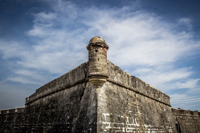 A garita (guard tower) with a cloudy sky in the background.