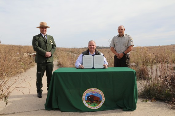 Secretary Bernhardt with NPS and FWS leadership at a table after the signing