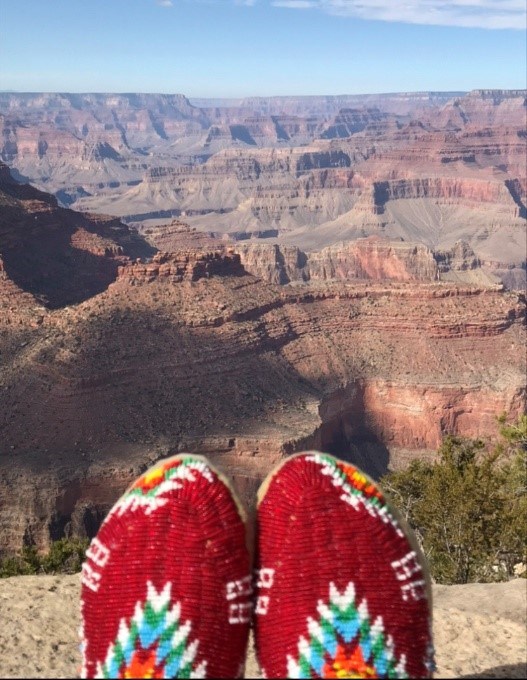 A pair of bright red moccasins at the edge of the Grand Canyon.