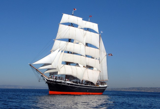 Tall sailing ship with full sails underway