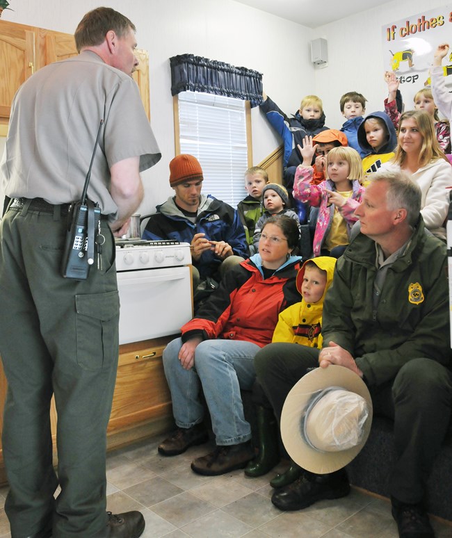 lt= Park ranger talks to a group of children and adults about fire prevention