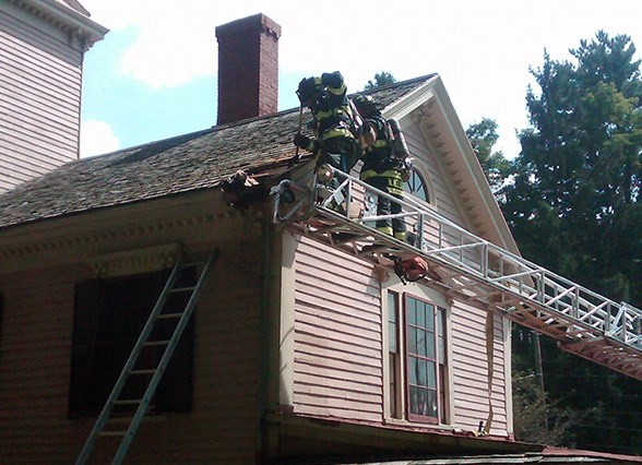 firefighters working to put out a structural fire on a two story building