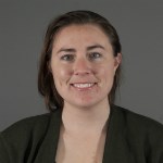 Headshot of smiling woman in black. Headshot of smiling woman in black.