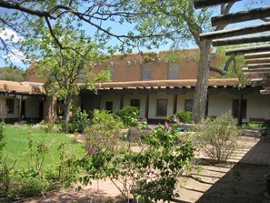 Adobe building and courtyard with purple flowers
