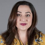 A woman with brown hair in yellow shirt