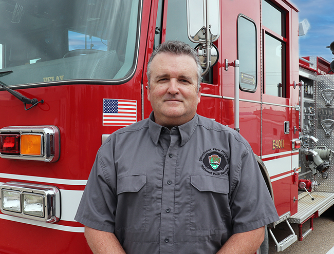 Mike Schell A person stands in front of a fire engine.