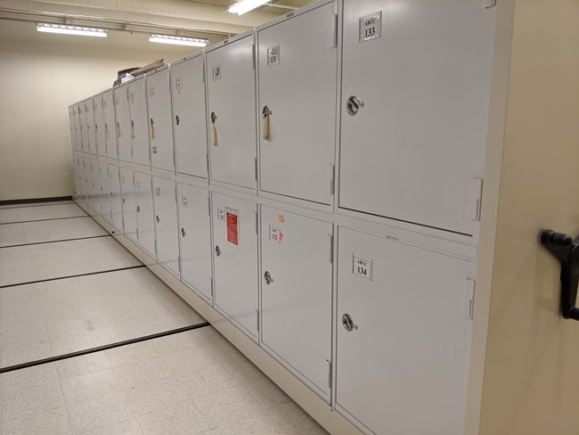 Collection storage at the Alaska Regional Curatorial Center A row of professional object collection storage at the Alaska Regional Curatorial Center. The storage containers are nearly floor to ceiling in a white room illuminated by florescent light.