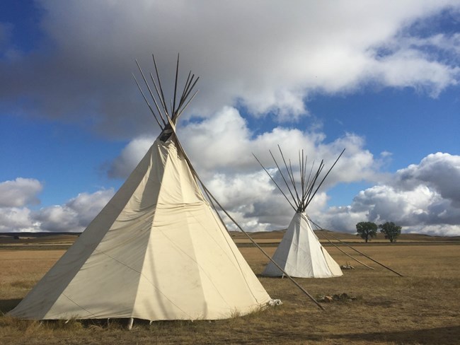 Two tipis in a mixed-grass prairie.