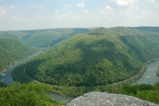 A view of horseshoe bend in a river, winding between green hills, from Grandview’s Main Outlook.