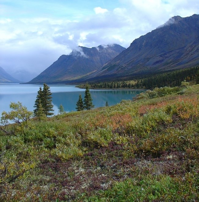 Lake surrounded by cloud-capped mountains