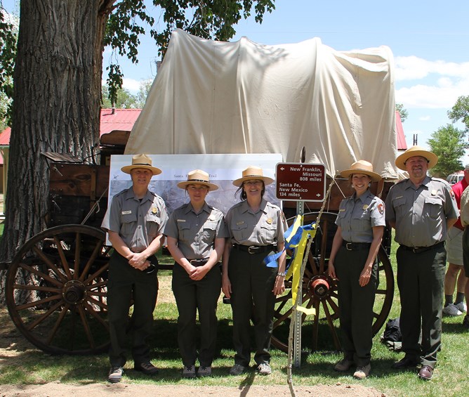 Five rangers in front of a Prairie Schooner wagon