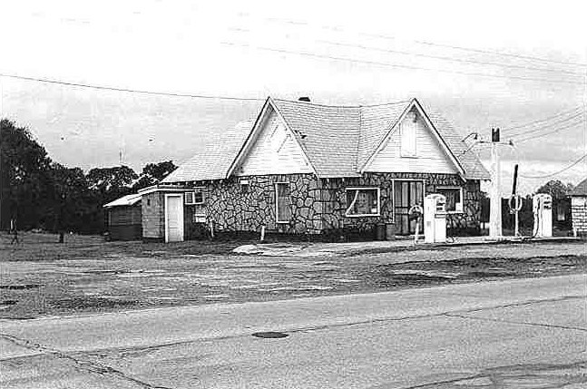 lt= A historic black and white image of a gas station.