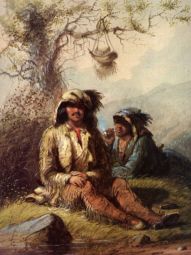 two men in buckskin on the grass, tree behind them
