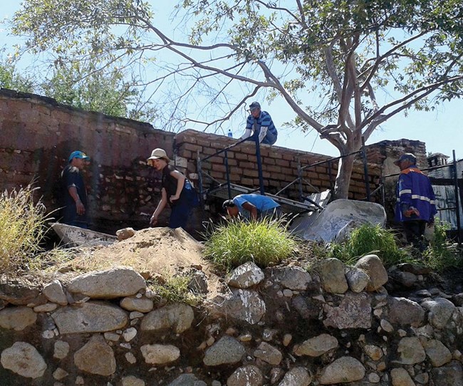 workers re-building a wall with adobe bricks