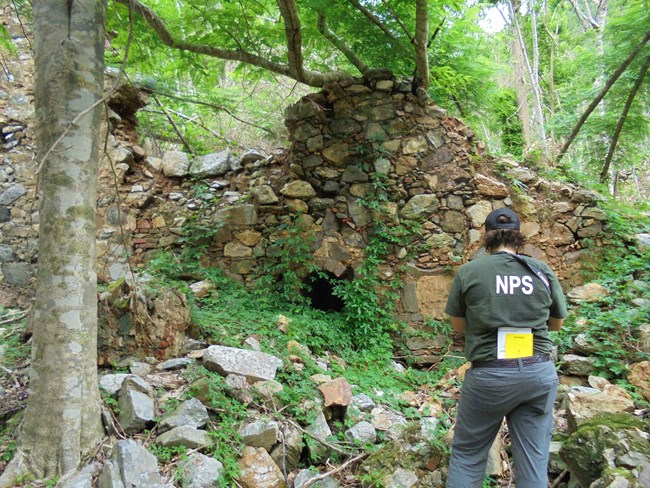 NPS archeologist surveys a historic structure