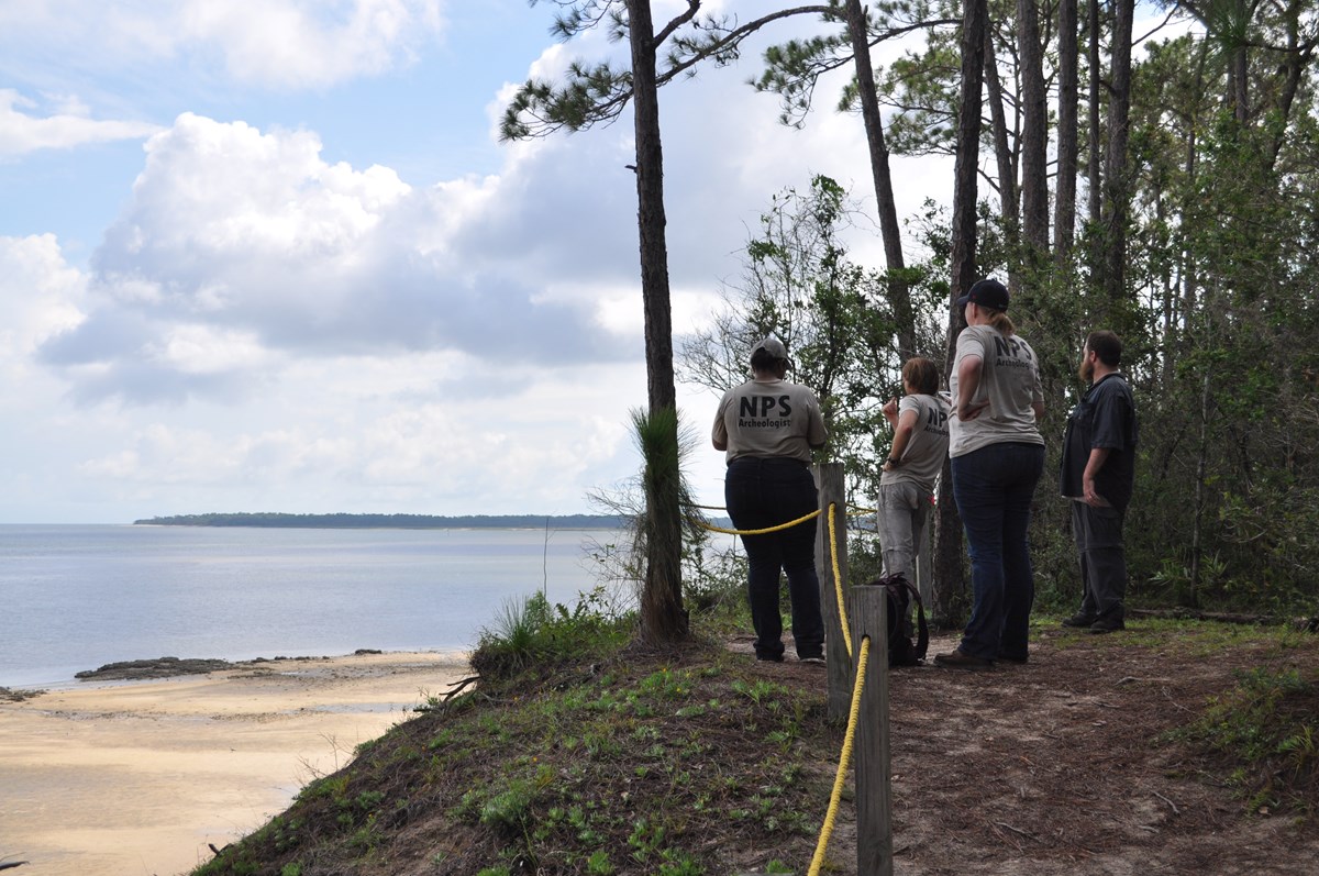 NPS archeologists standing near shoreline