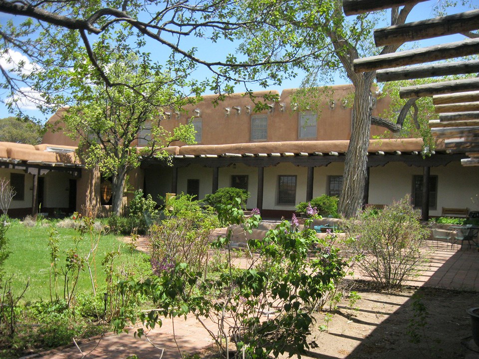 Old Santa Fe Trail Building landscape with adobe building, patio, and courtyard.