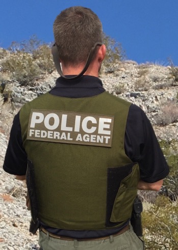 A Special Agent of the National Park Service Investigative Services Branch (ISB) stands in a desert landscape in Lake Mead National Recreation Area. NPS photo. A Special Agent of the National Park Service Investigative Services Branch (ISB) stands in a desert landscape in Lake Mead National Recreation Area. NPS photo.