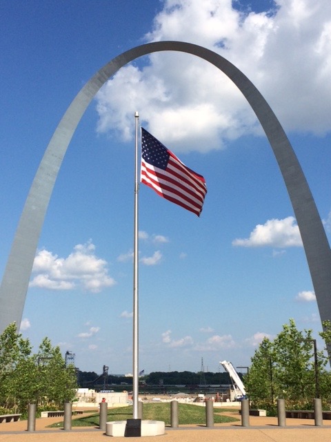 The United States flag flies beneath the Gateway Arch in Jefferson National Expansion Memorial. NPS photo by J Sullivan.