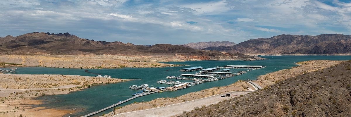 NPS file photo of Callville Bay in Lake Mead National Recreation Area. An overview of Callville Bay in Lake Mead National Recreation Area. Many boats are docked in a marina within a narrow inlet of a lake in a desert environment.