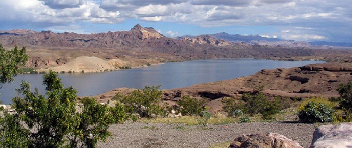 A timely response by US Park Rangers of Lake Mead National Recreation Area and an investigation by the National Park Service Investigative Services Branch has concluded with a woman being sentenced to prison for child abuse. The waters of Lake Mohave are flanked by desert cliffs and sparse vegetation. NPS photo.