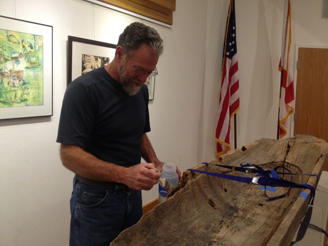 Conservator treating a Seminole canoe on exhibit at Big Cypress National Preserve Conservator treating a Seminole canoe on exhibit at Big Cypress National Preserve