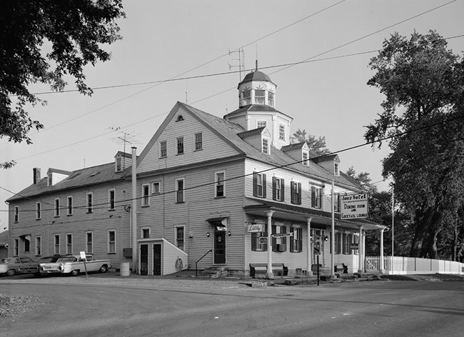 Frame hotel building next to road. Frame hotel building next to road.