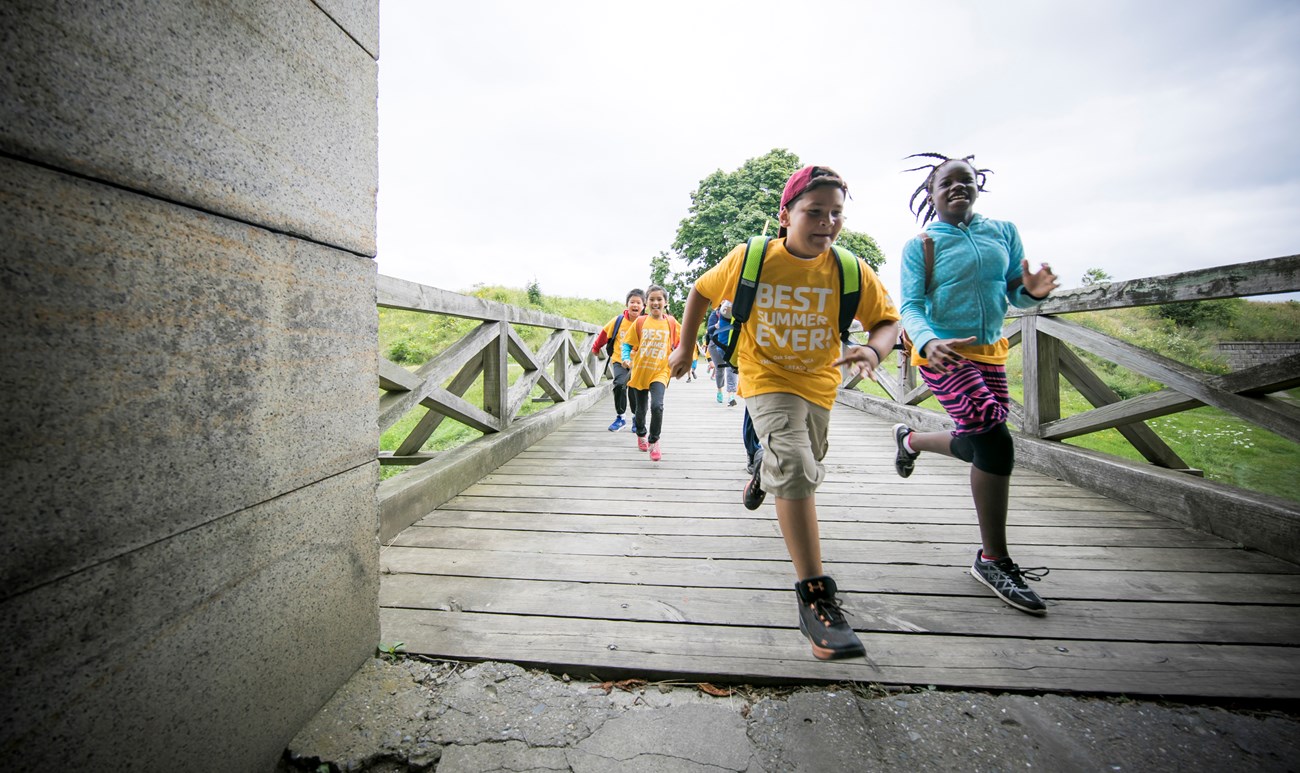 Young girls and boys running along a path.