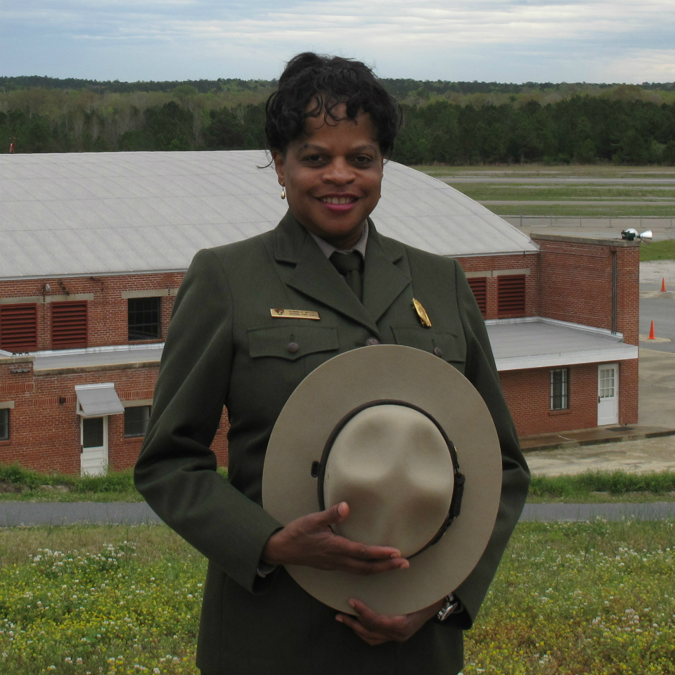 A woman in an NPS uniform faces the camera