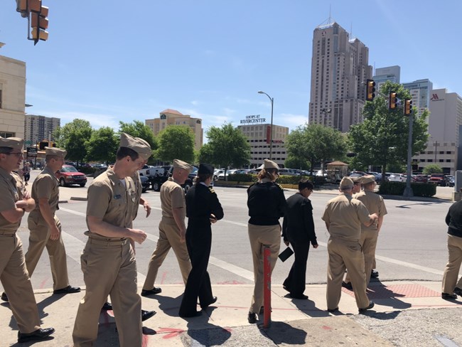 PHS officers meet for public health training in San Antonio A group of men and women in tan uniforms walk along a street.