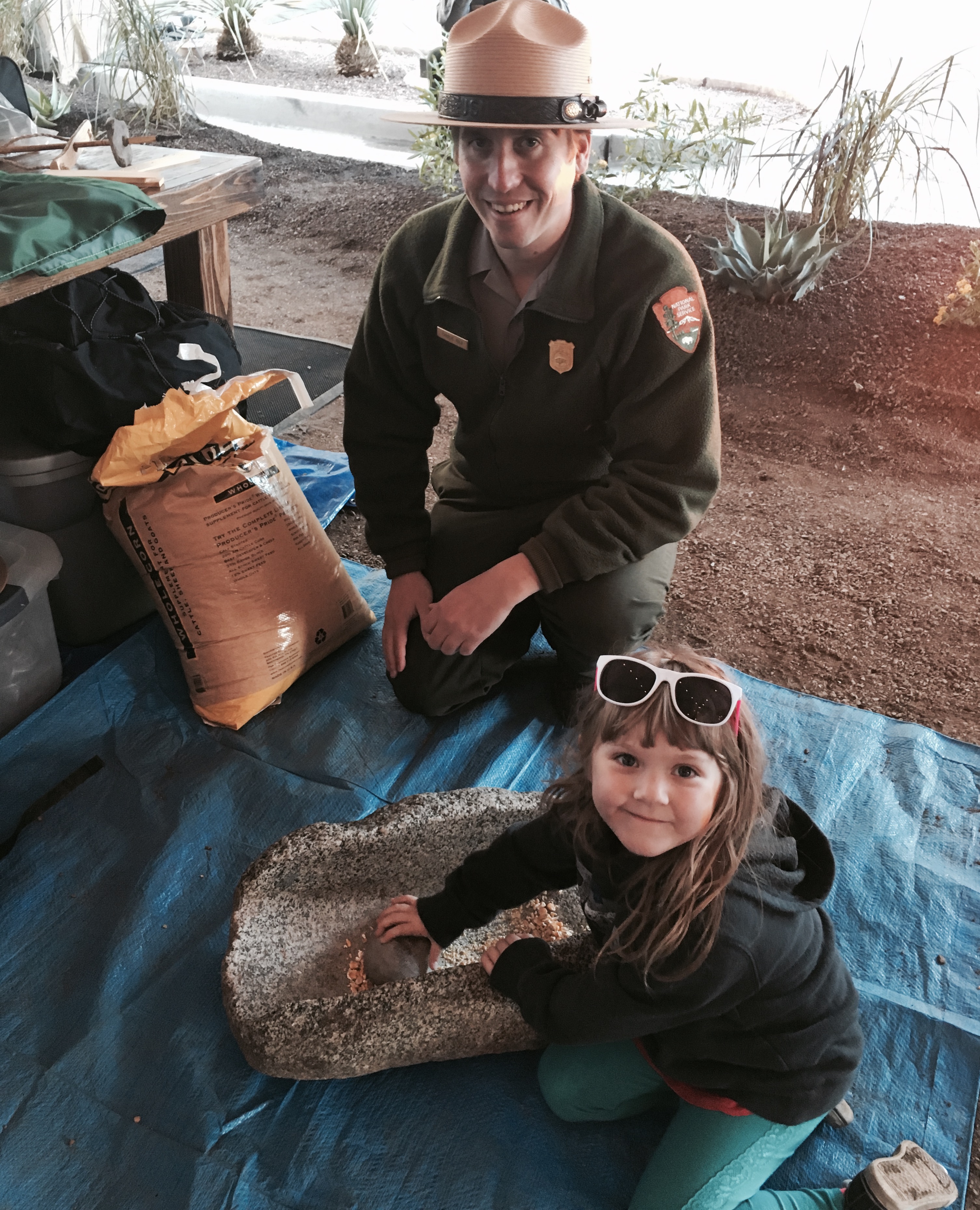 Charlie Kolb, a park ranger from Organ Pipe Cactus National Monument, demonstrates how to use a mano and metate for a young visitor.