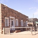 A masonry building with old wooden buggy outside.