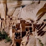 Masonry rooms seen from above in a cliff alcove.