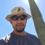 Theo Ramlal A man in sunglasses stands in front of a saguaro