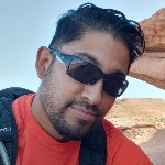 Ramlal_ A man in sunglasses and red shirt looks at the camera