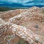 Low masonry walls seen from above reveal square rooms.