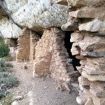 Masonry walls under a cliff overhang.