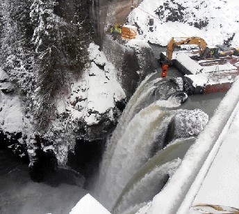 Construction workers and equipment working at the top of dam at Glines Canyon in Olympic National Park. Construction workers and equipment working at the top of dam at Glines Canyon in Olympic National Park.