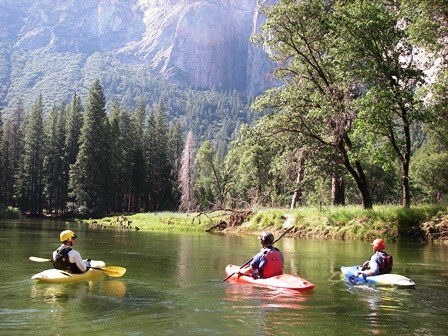 Visitors enjoying the Merced River at Yellowstone National Park. 3 people canoeing on the Merced River.
