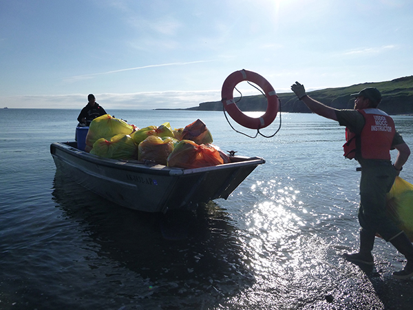volunteer throws bag on to boat