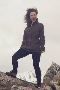MK Reeder a woman stands on a rocky ledge