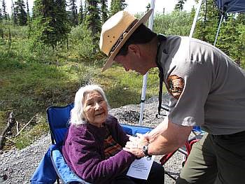 A park ranger shakes hands with an elderly woman