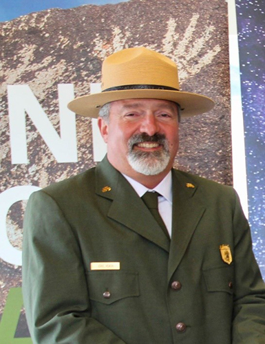 Eric Veach Superintendent Eric Veach faces towards the camera. He is in uniform, wearing a Ranger's hat and smiling.